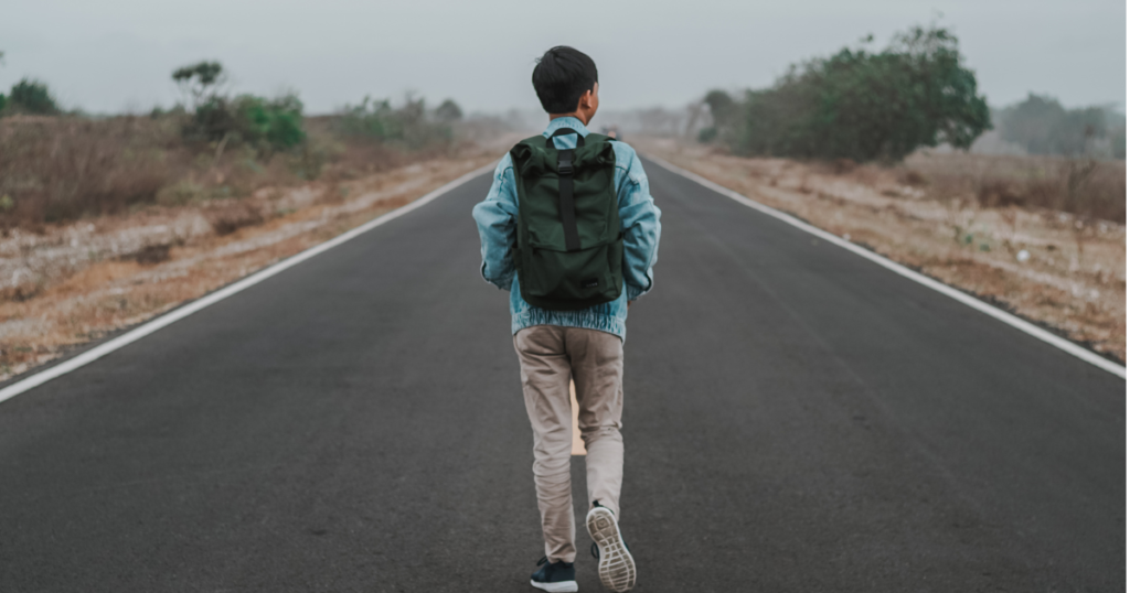 道を前に向かって歩いている男性